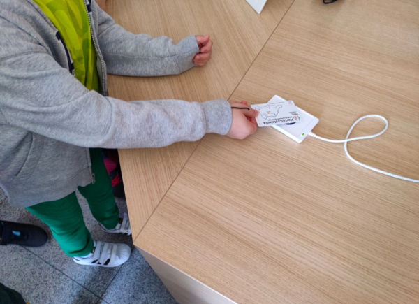 Dziecko przykłada kartę do czytnika