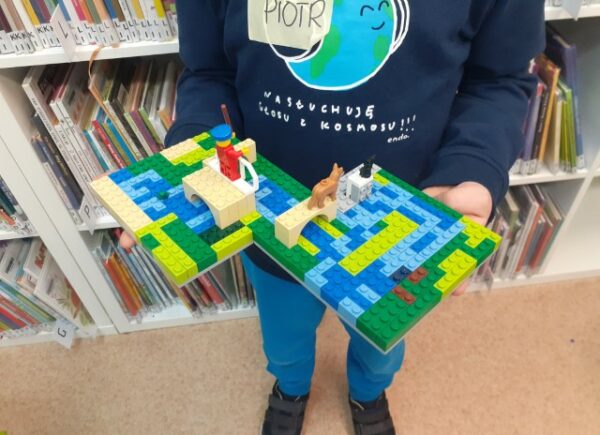 Dziecko pokazuje swoją budowlę z lego