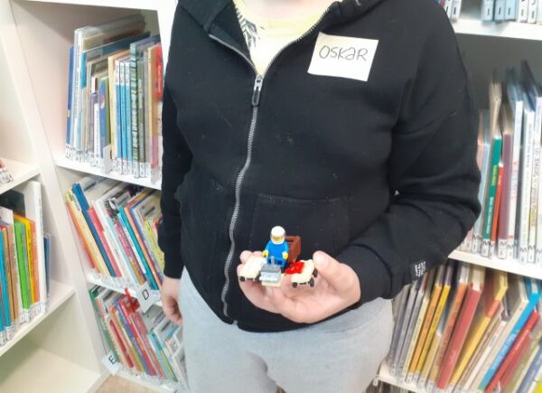 Dziecko pokazuje swoją budowlę z lego