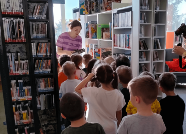 Bibliotekarka oprowadza dzieci po bibliotece