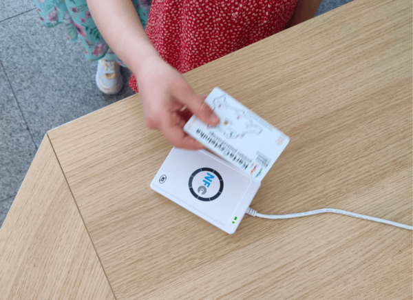 Dziecko przykłada kartę biblioteczną do czytnika