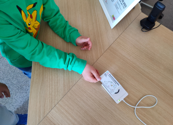 Dziecko przykłada kartę do czytnika