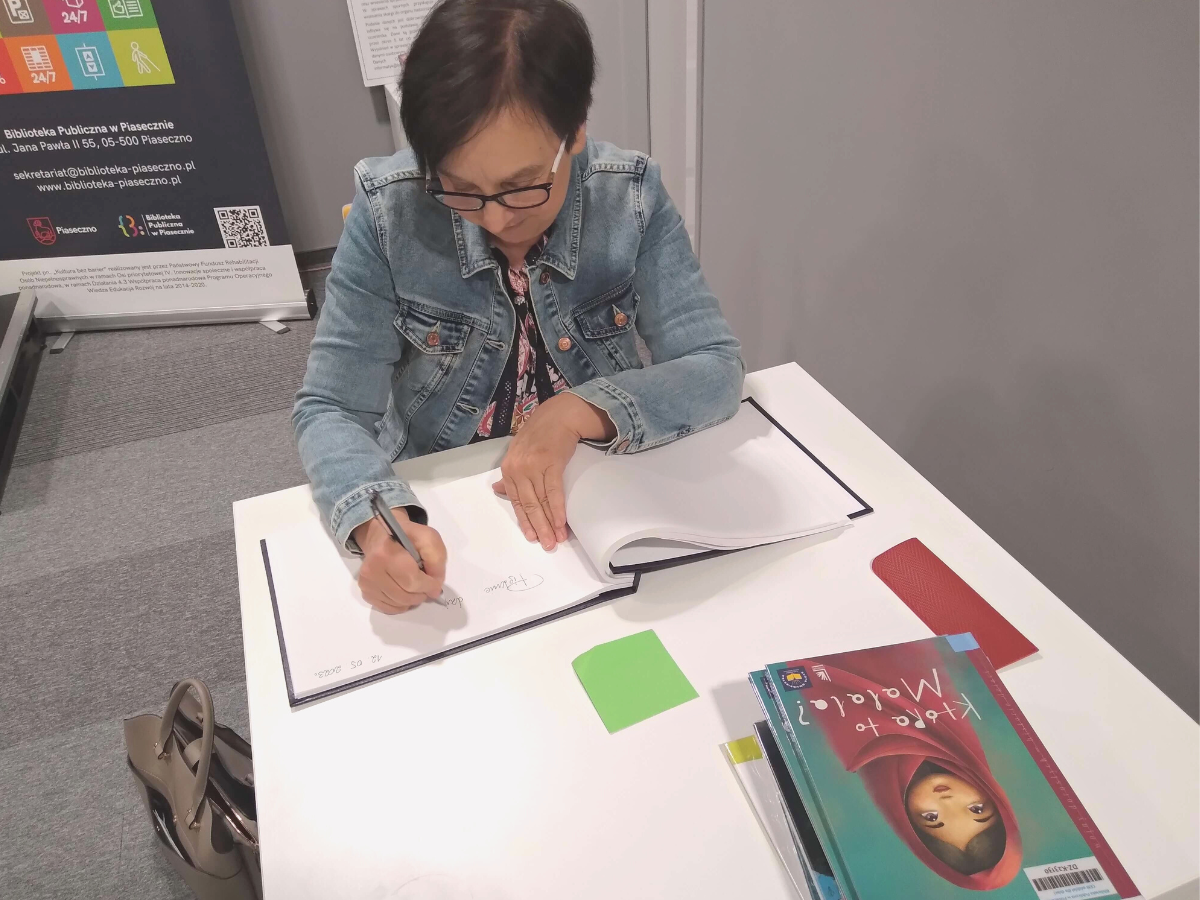 Pisarka Renata Piątkowska podczas podpisywania swoich książek w Oddziale dla dzieci i młodzieży Biblioteki Głównej w Piasecznie