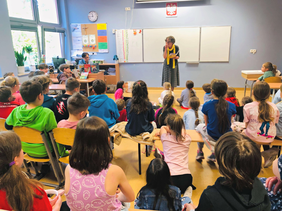 Lektorka, pani Malwina czyta dzieciom fragmenty książek podczas spotkania w filii w Zalesiu Dolnym