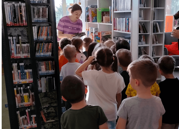 Bibliotekarka oprowadza dzieci po bibliotece