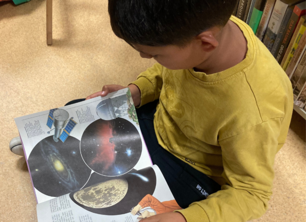 Uczniowie oglądają książki na temat kosmosu