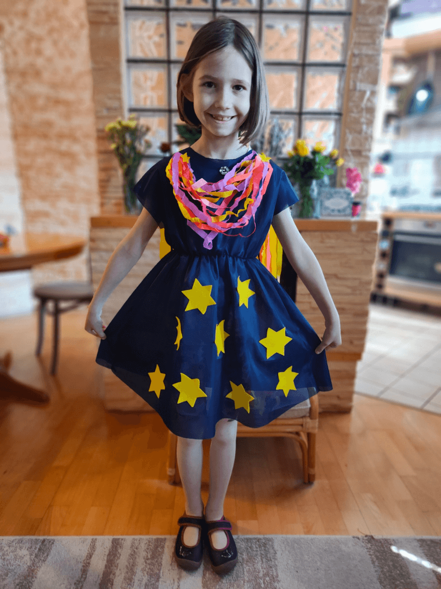 Dziewczynka pozuje do zdjęcia w przygotowanej na pokaz sukience