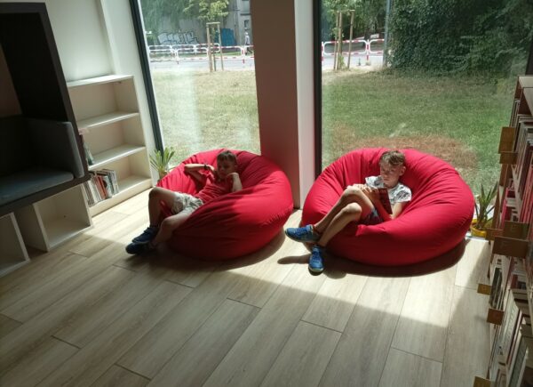 Dzieci odpoczywają na czerwonych pufach