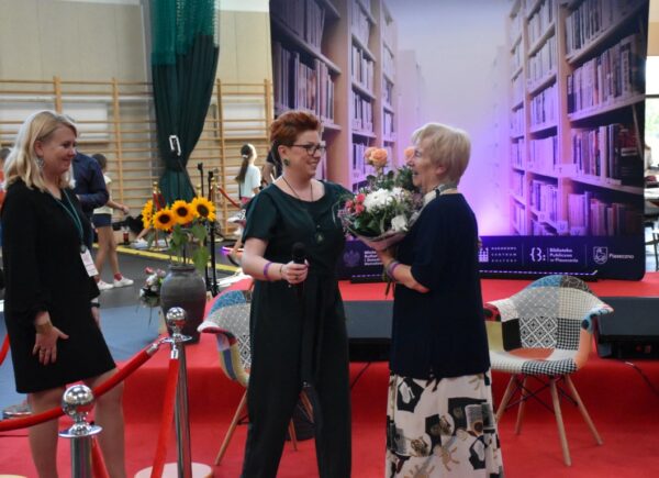 Urszula Bąkowska oraz Zastępca Dyrektora Biblioteki Sylwia Chojnacka-Tuzimek wreczają kwiaty autorce Irenie Krowickiej