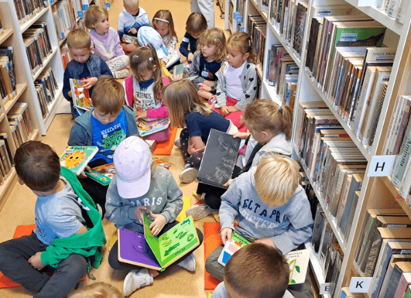 Przedszkolaki oglądają biblioteczne książeczki