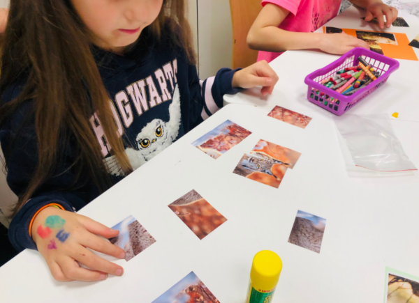 Dziewczynka układa puzzle przedstawiające wizerunek rysia