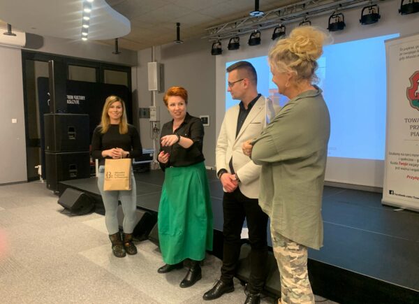 Zastępca Dyrektora Biblioteki, Sylwia Chojnacka-Tuzimek, oraz komisja konkursowa podczas rozdania nagród laureatom konkursu "Piaseczno 2023 w obiektywie"
