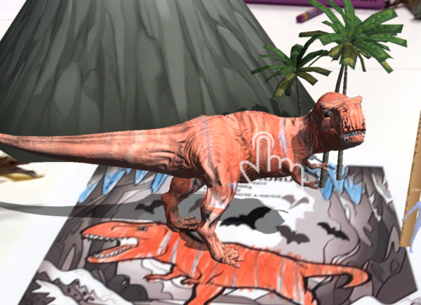 Zdjęcie prezentuje dinozaura pokolorowanego przez uczestniczkę warsztatów przeniesionego do rzeczywistości rozszerzonej