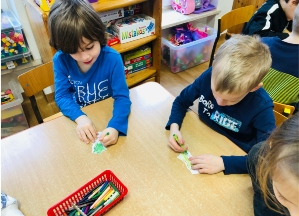 Dzieci kolorują dinozaury z papieru