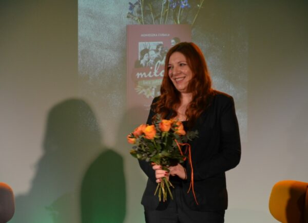 Autorka Agnieszka Cubała na scenie z kwiatami po spotkaniu autorskim w Bibliotece Publicznej w Piasecznie