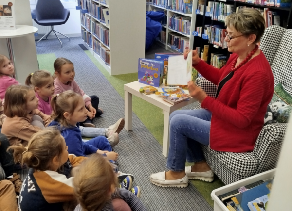 Pani bibliotekarka pokazuje dzieciom różne rodzaje książek