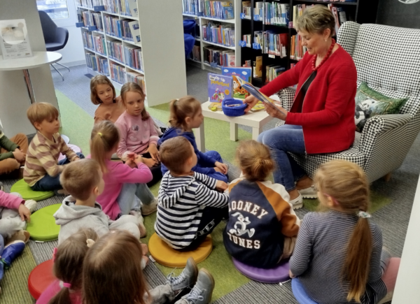 Dzieci odgadują zagadki zadawane przez panią bibliotekarkę
